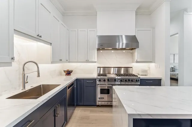 a kitchen with stainless steel appliances granite countertop a sink stove and refrigerator