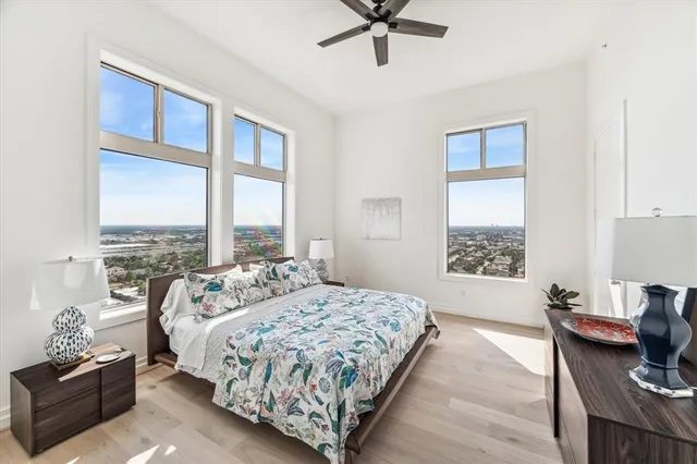 a bedroom with a bed couch and windows