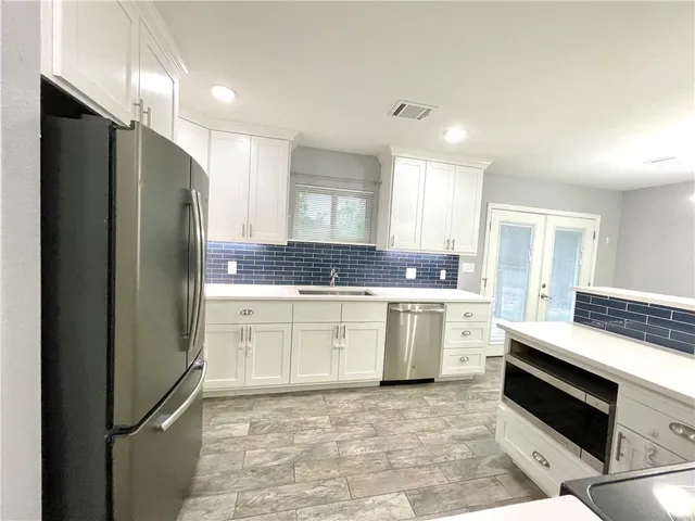 a kitchen with a refrigerator and a stove top oven
