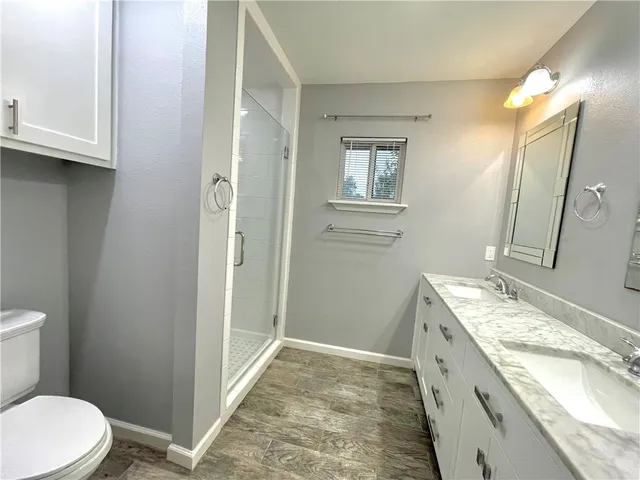 a bathroom with a granite countertop sink toilet and shower