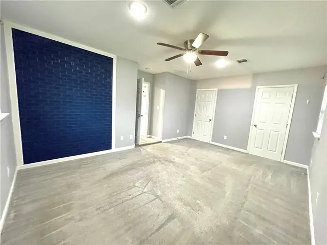 a view of an empty room with a ceiling fan