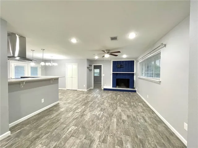 a view of an empty room and kitchen