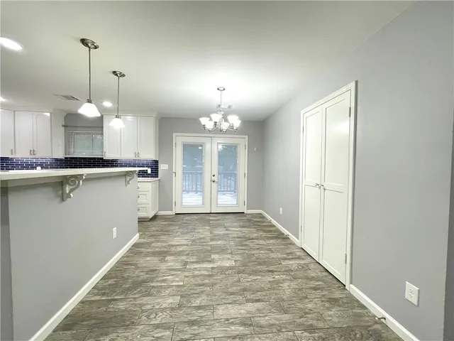 a view of a kitchen with a sink wooden cabinets and chandelier