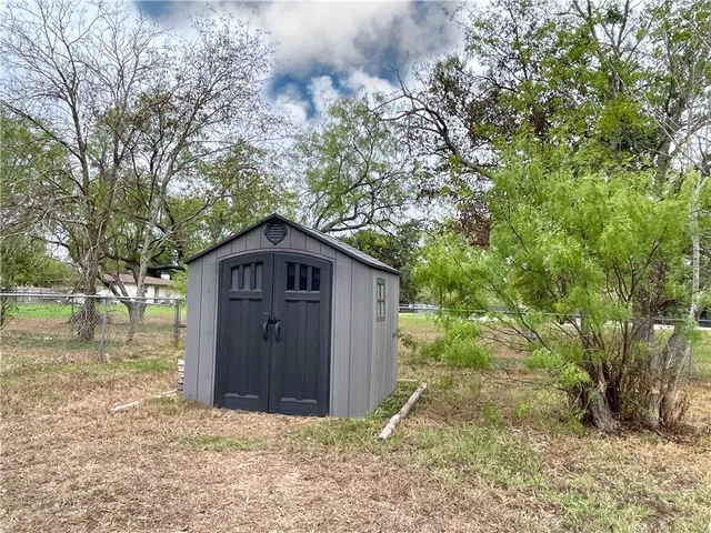a wooden house with a tree in the background