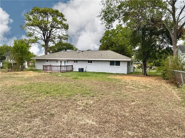 a front view of a house with a garden and tree