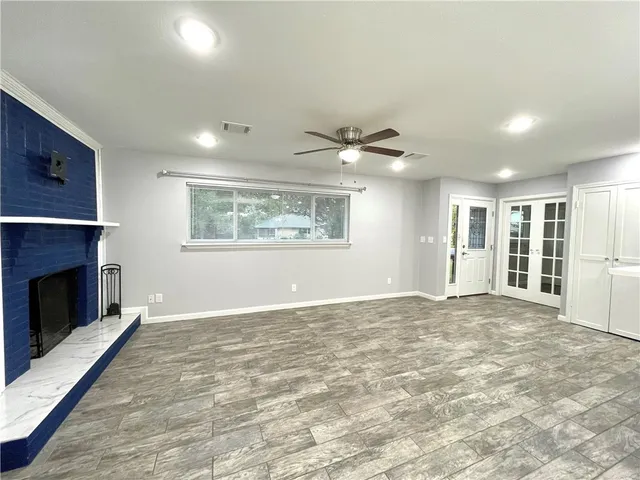 a view of an empty room with a fireplace and a window