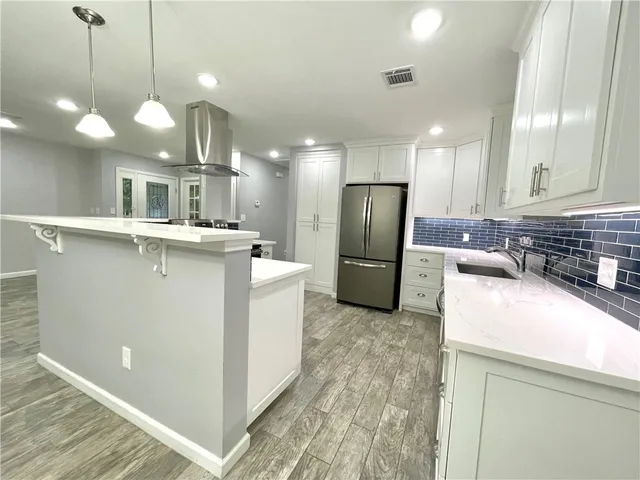 a kitchen with stainless steel appliances granite countertop a sink a refrigerator and a stove