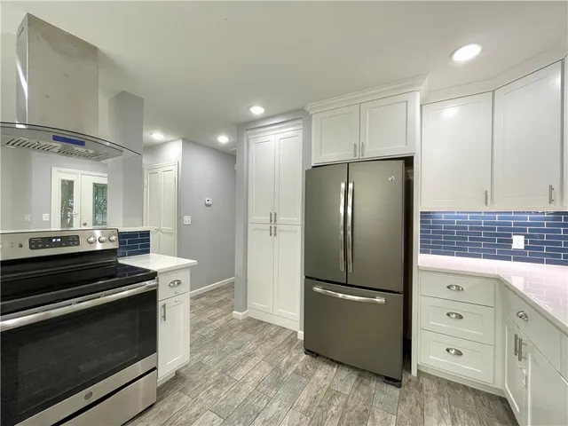 a kitchen with granite countertop a refrigerator and a stove top oven
