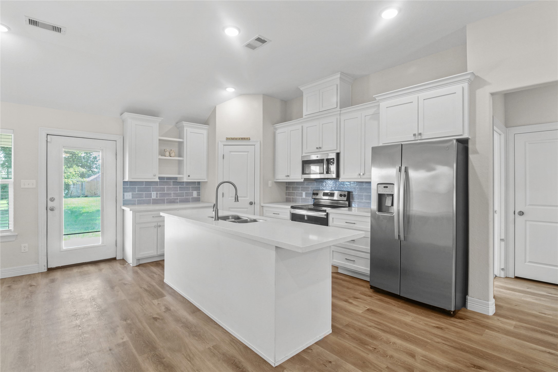 1208 East Henderson Road Angleton, TX 77515 - Photo 7 of 29 a kitchen with stainless steel appliances granite countertop a refrigerator a sink dishwasher a stove top oven a refrigerator with white cabinets and wooden floor