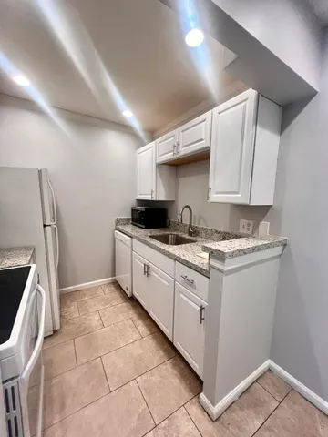 a kitchen with stainless steel appliances granite countertop a sink and a stove top oven