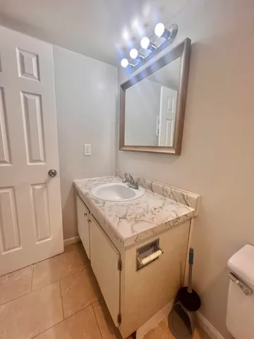 a view of an empty room with chandelier fan