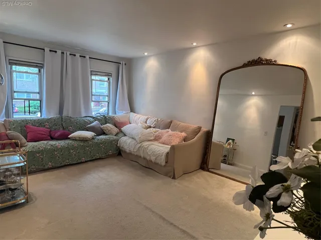 a living room with furniture and a mirror