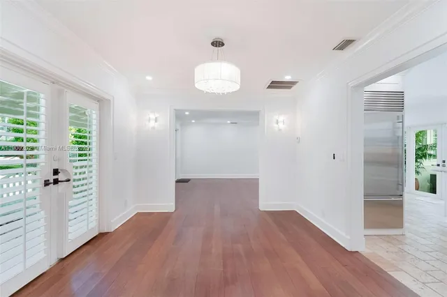a view of a big room with wooden floor and windows