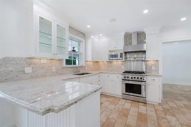 a kitchen with stainless steel appliances granite countertop a refrigerator and a sink