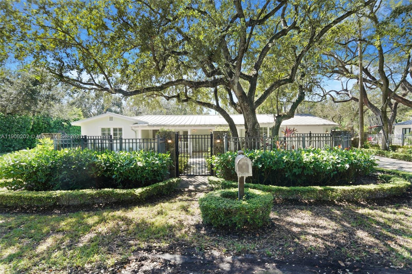 4920 Southwest 76th Street Miami, FL 33143 - Photo 3 of 36 a front view of a house with a yard and potted plants