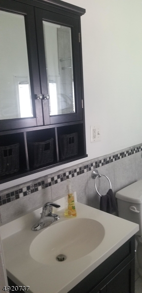 517 Woodlawn Avenue Linden, NJ 07036 - Photo 6 of 7 a bathroom with a sink and a mirror