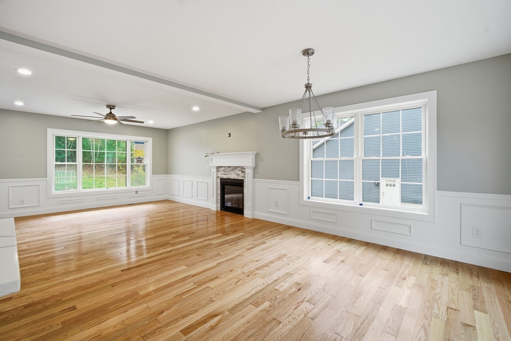23 High Blf Road Belchertown, MA 01007 - Photo 8 of 39 an empty room with wooden floor fireplace and windows