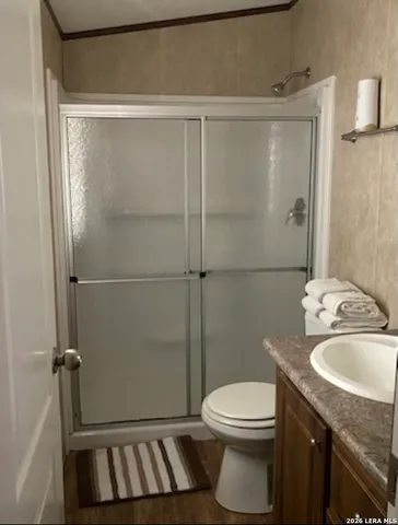 a bathroom with a granite countertop sink toilet and shower