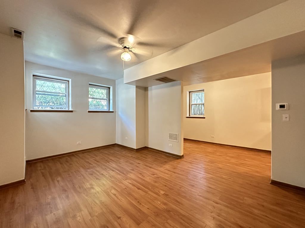 3832 North Fremont Street, Unit G Chicago, IL 60613 - Photo 11 of 20 a view of an empty room with wooden floor and a window