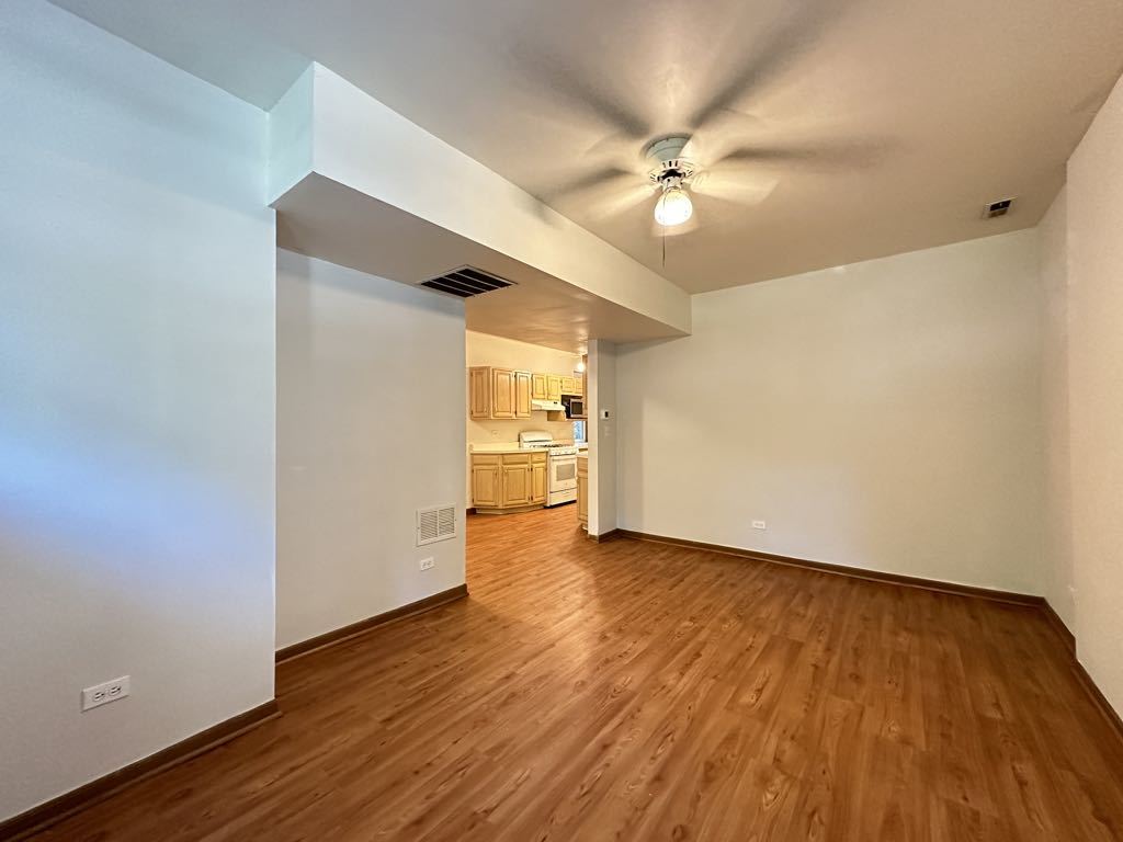 3832 North Fremont Street, Unit G Chicago, IL 60613 - Photo 13 of 20 a view of a livingroom with wooden floor and a ceiling fan