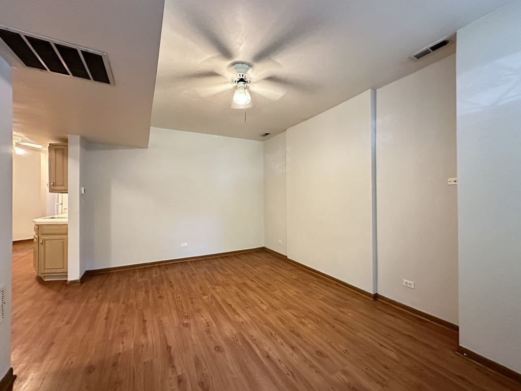 3832 North Fremont Street, Unit G Chicago, IL 60613 - Photo 15 of 20 an empty room with wooden floor closet and windows