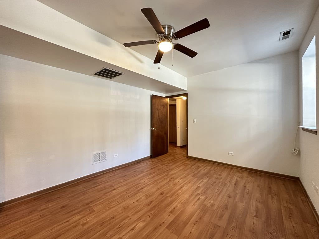 3832 North Fremont Street, Unit G Chicago, IL 60613 - Photo 17 of 20 an empty room with wooden floor and ceiling fan