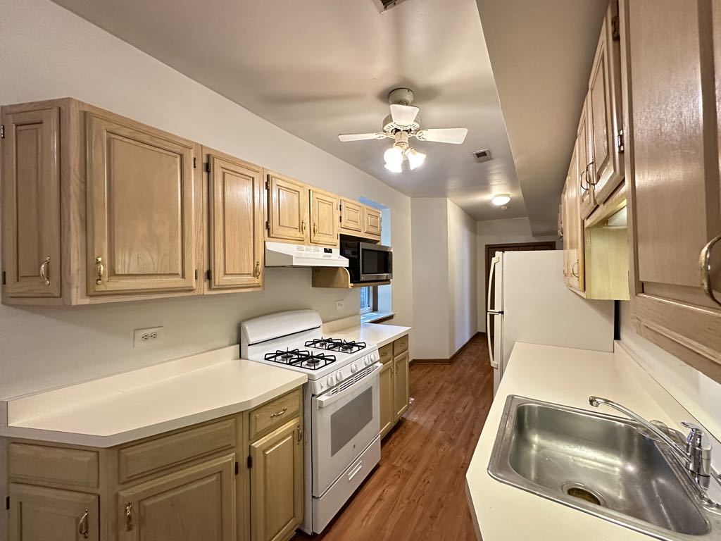 3832 North Fremont Street, Unit G Chicago, IL 60613 - Photo 4 of 20 a kitchen with stainless steel appliances a stove a sink and a refrigerator