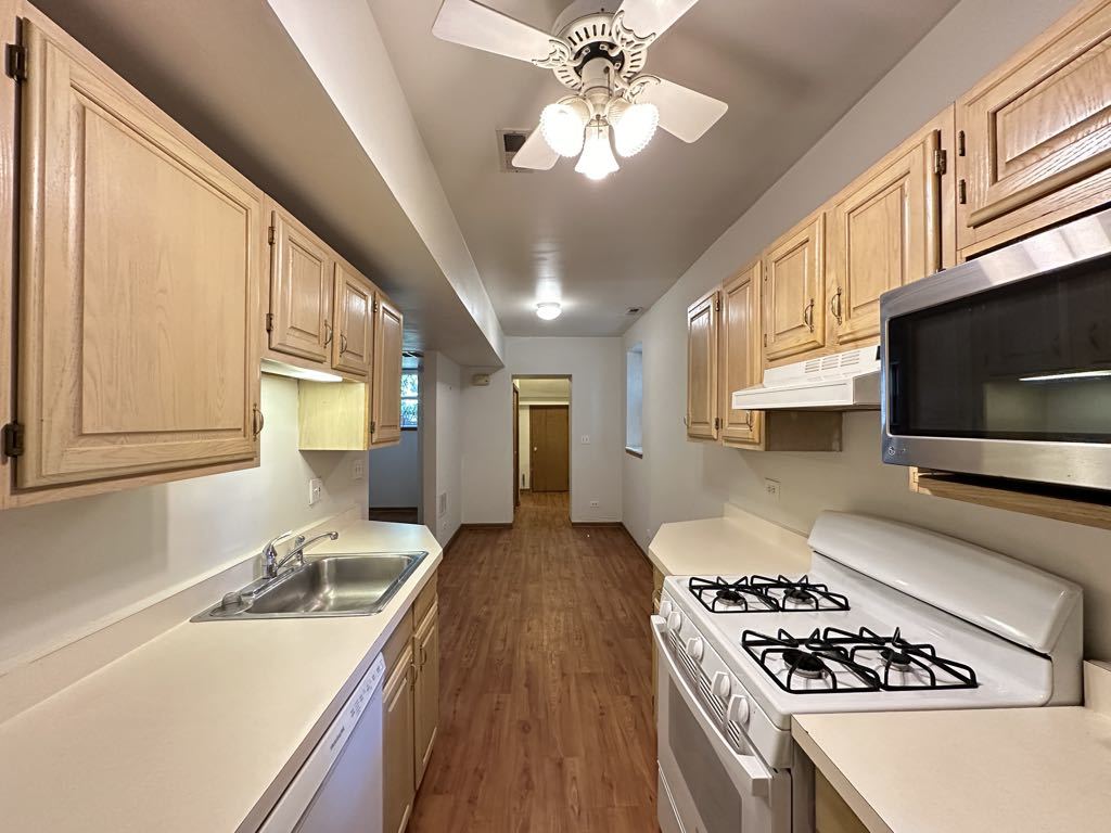 3832 North Fremont Street, Unit G Chicago, IL 60613 - Photo 5 of 20 a kitchen with stainless steel appliances a stove a sink and a microwave