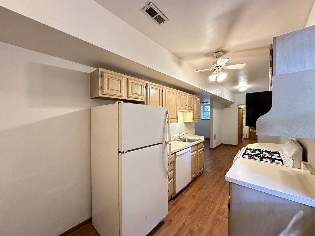 3832 North Fremont Street, Unit G Chicago, IL 60613 - Photo 6 of 20 a kitchen with a refrigerator a stove and a sink with wooden floor