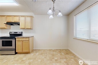 1910 J Street, Unit 102 Walla Walla, WA 99362 - Photo 14 of 20 a view of a kitchen with a stove cabinets and a wooden floor