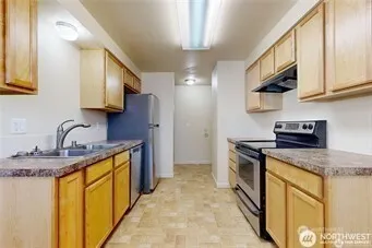 a kitchen with stainless steel appliances granite countertop a refrigerator and a stove