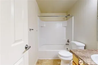 a bathroom with a granite countertop toilet a sink and shower
