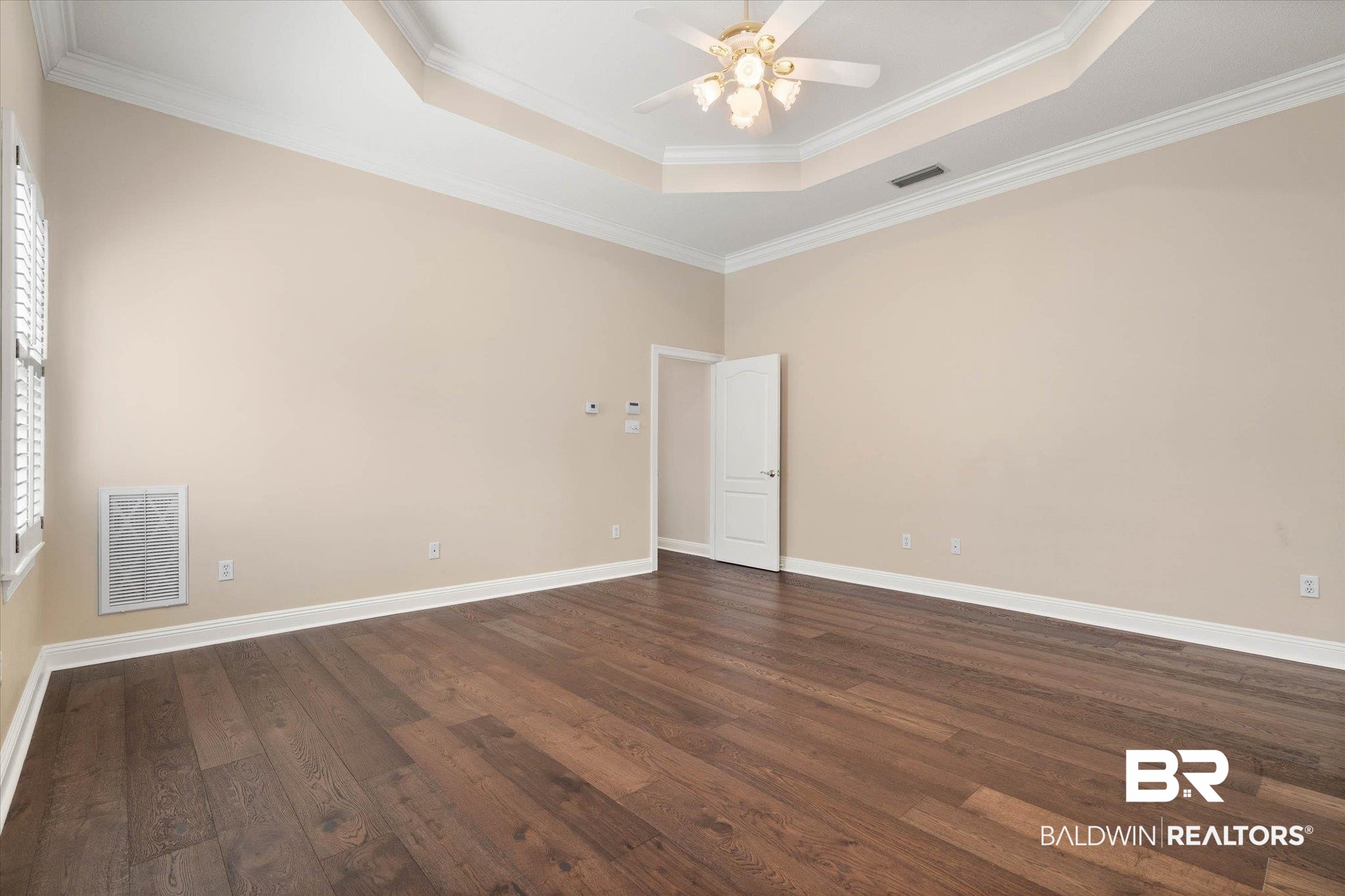 1083 Southern Way Court Mobile, AL 36609 - Photo 18 of 31 Unfurnished room with crown molding, a ceiling fan, dark wood finished floors, and a raised ceiling