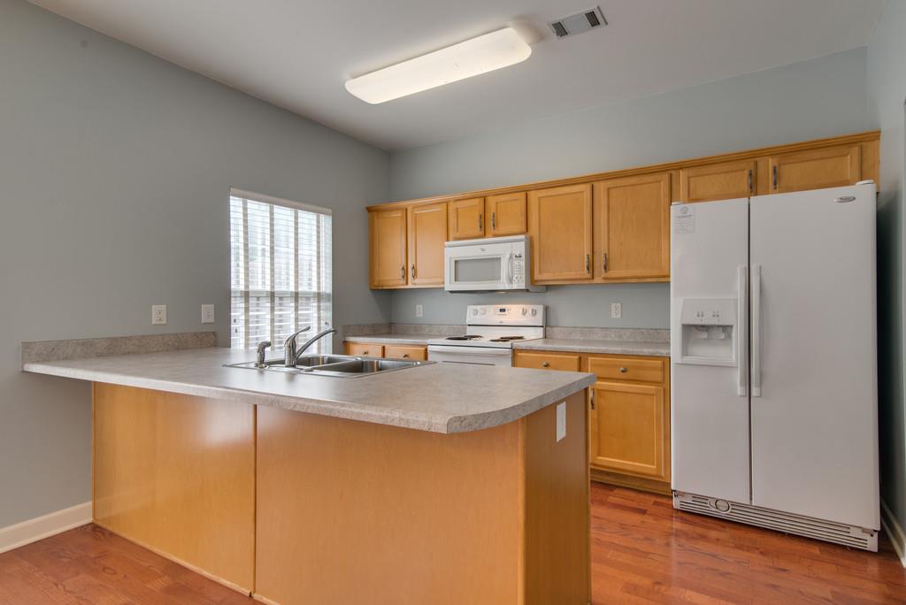 553 Rosedale Avenue, Unit 127 Nashville, TN 37211 - Photo 7 of 27 a kitchen with stainless steel appliances granite countertop a sink a stove a refrigerator with grey cabinets