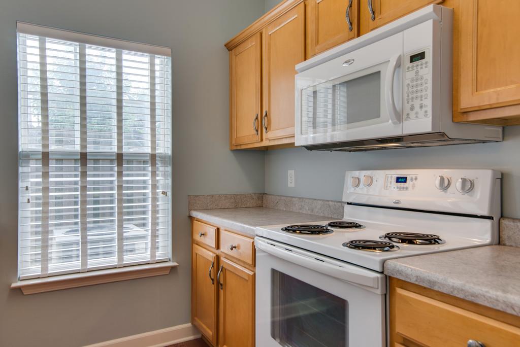 553 Rosedale Avenue, Unit 127 Nashville, TN 37211 - Photo 10 of 27 a kitchen with granite countertop a stove a sink and a microwave