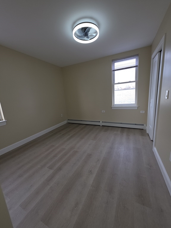 475 Purchase Street, Unit 3 New Bedford, MA 02740 - Photo 18 of 20 an empty room with wooden floor and windows