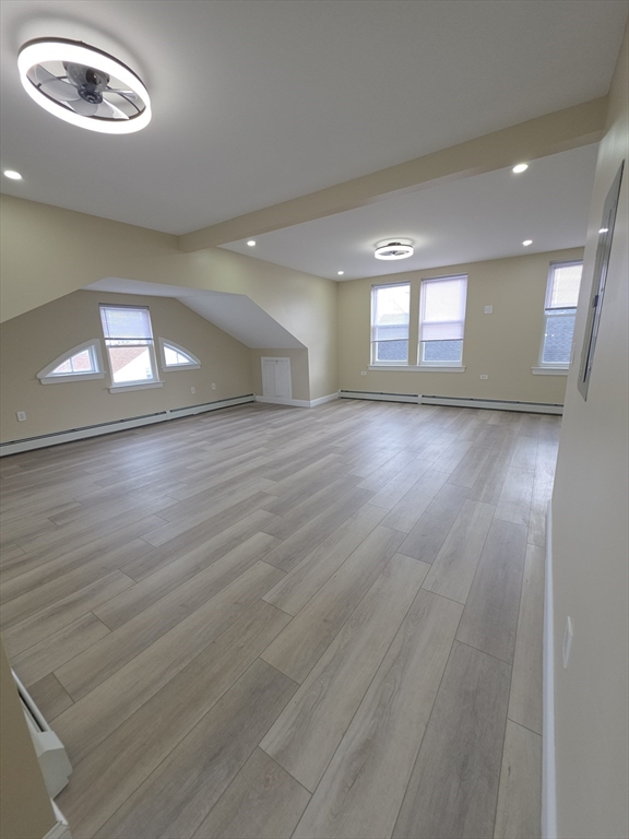 475 Purchase Street, Unit 3 New Bedford, MA 02740 - Photo 8 of 20 an empty room with wooden floor and windows