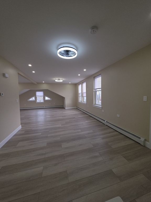 475 Purchase Street, Unit 3 New Bedford, MA 02740 - Photo 10 of 20 an empty room with wooden floor and windows