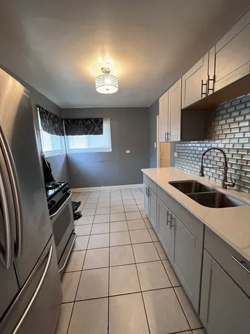 a kitchen with stainless steel appliances a sink a stove a microwave and cabinets