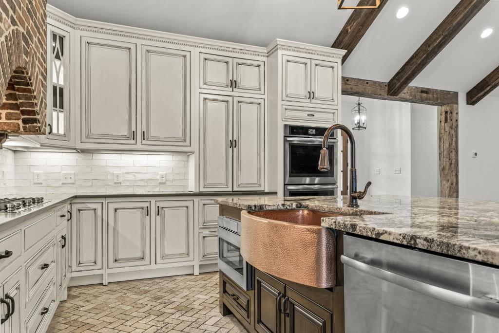 300 Potts Lane Covington, GA 30016 - Photo 41 of 76 a kitchen with granite countertop white cabinets and stainless steel appliances