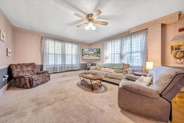 a living room with furniture a large window and a chandelier