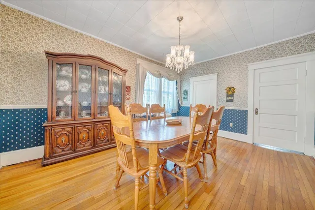 a view of a dining room with furniture a chandelier and wooden floor