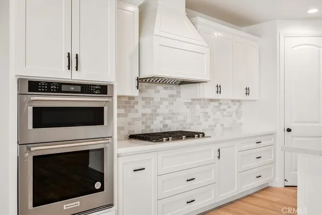 a kitchen with white cabinets and appliances