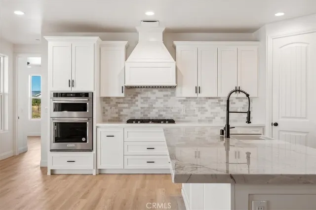 a kitchen with stainless steel appliances white cabinets and a stove
