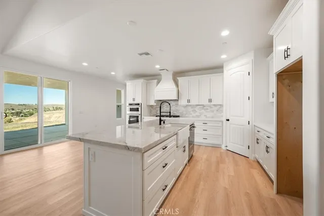 a large kitchen with kitchen island a sink stainless steel appliances and cabinets