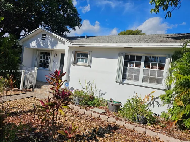 a kitchen with a refrigerator a stove and white cabinets