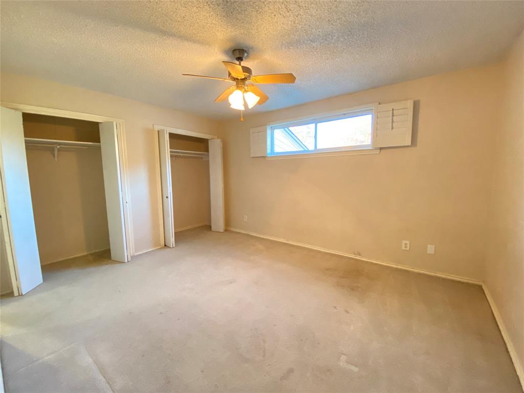 606 Old Country Road Duncanville, TX 75137 - Photo 13 of 22 an empty room with a chandelier fan and windows