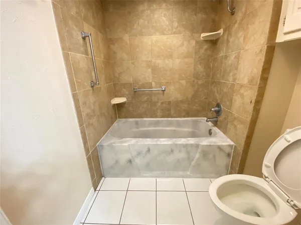 a bathroom with a granite countertop sink a toilet a mirror and a shower