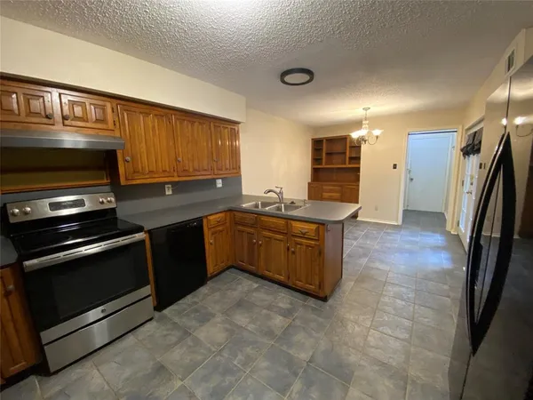 a kitchen with stainless steel appliances granite countertop a stove microwave and sink
