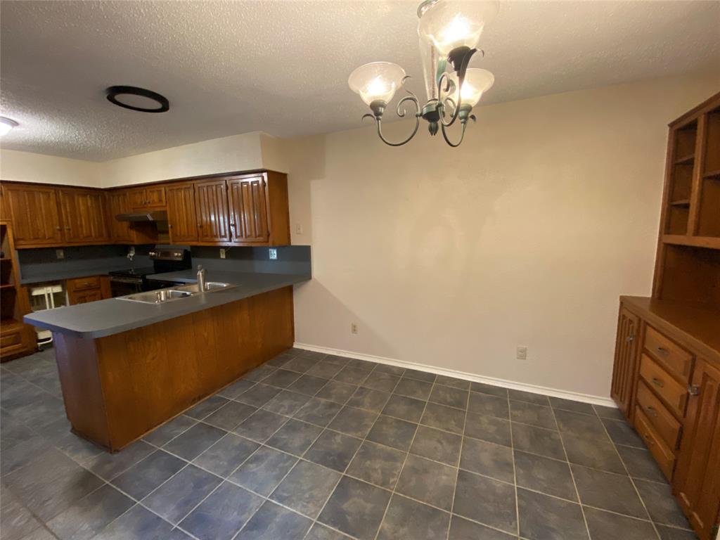 606 Old Country Road Duncanville, TX 75137 - Photo 10 of 22 a kitchen with kitchen island granite countertop a sink a counter top space cabinets and stainless steel appliances